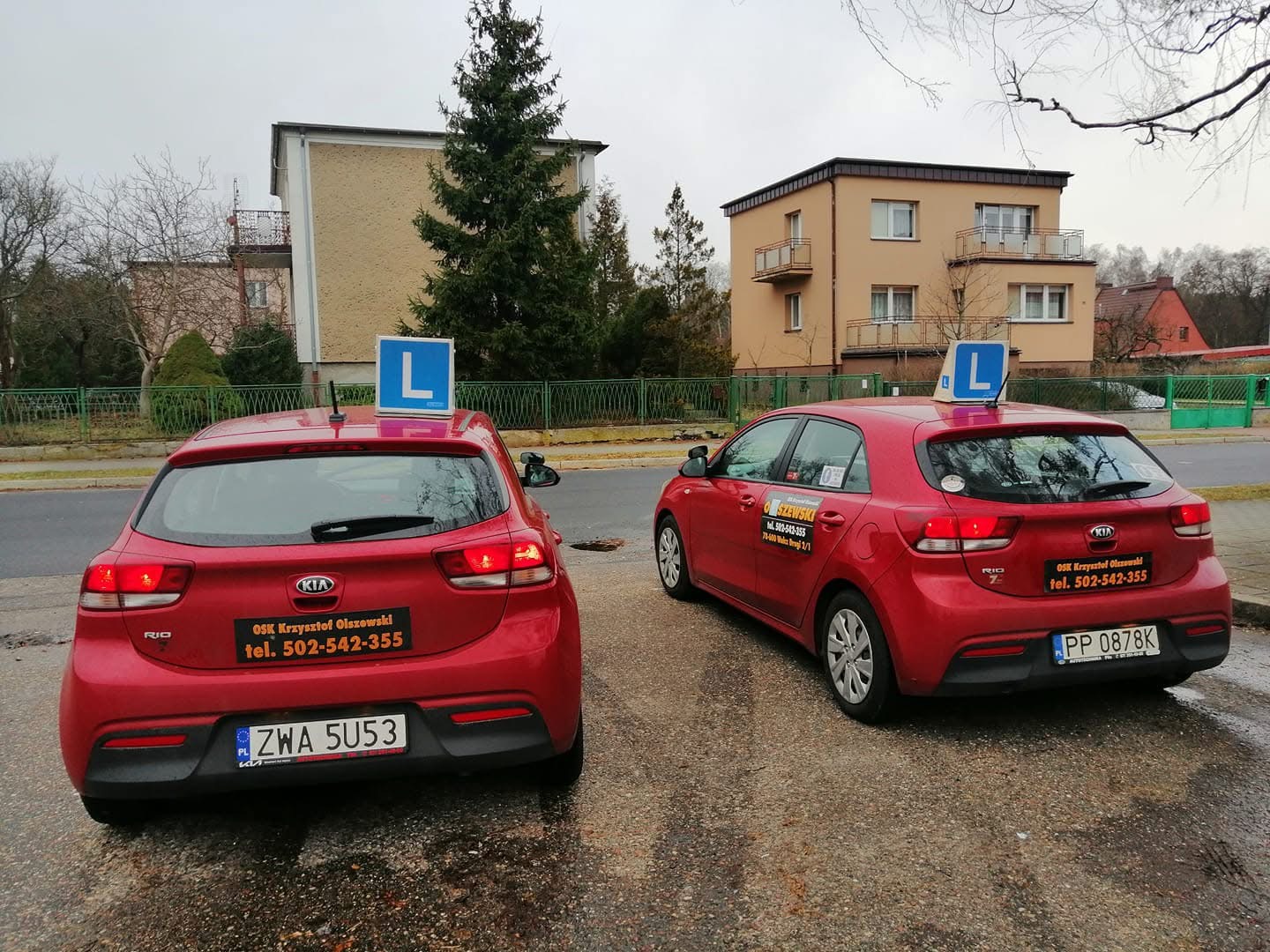 Dwa czerwone samochody KIA Rio z tablicami L — flota Olszewski Nauka Jazdy Walcz